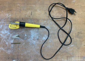 The electrified encaustic pen with three attachments, a pen nib, a brush nib and a small iron.